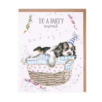 King Charles Spaniel in a party hat asleep on a pile of laundry birthday card